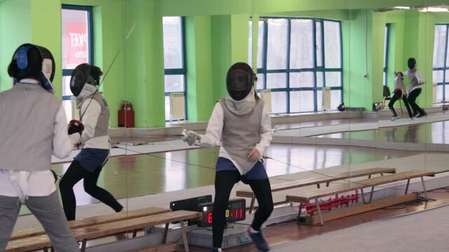 Teenagers practicing fencing at a fencing school 