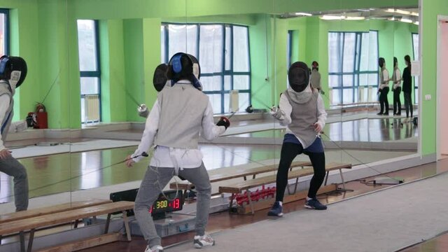 Teenagers practicing fencing at a fencing school 