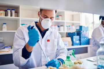 Male technician preparing samples at a table in a lab