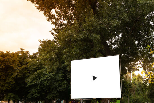 Open air cinema or theater, outdoors movie. Large movie screen, film playing on the sunset background