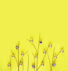 Willow twigs with quail and golden eggs on a yellow background