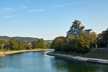 Fototapeta na wymiar Okayama castle overlooking the Asahi river at sunset, completed in 1597 by Ukita Naoie