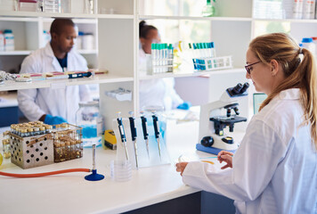 Female technician putting samples in petri dishes in a lab