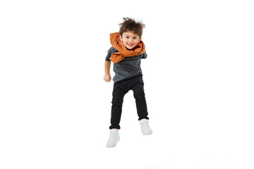 Jumping, flying. Happy, smiley little caucasian boy isolated on white studio background with copyspace for ad. Looks happy, cheerful. Childhood, education, human emotions, facial expression concept.