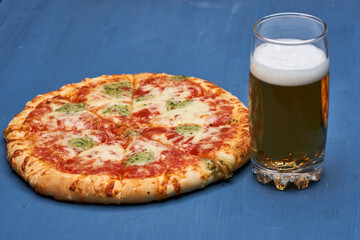 Delicious pizza on wooden board and beer