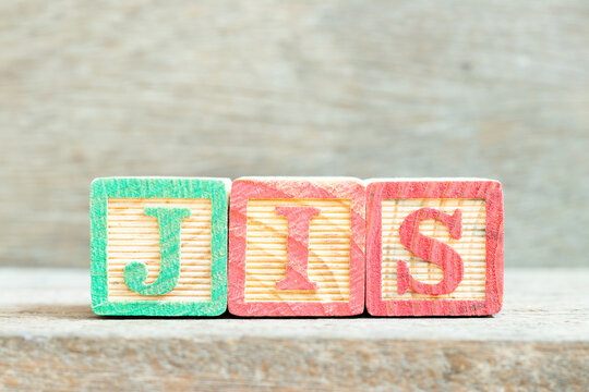Color alphabet letter block in word JIS (abbreviation of Just in sequence) on wood background