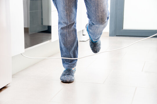 Close up of a woman legs stumbling with an electrical cord at kitchen