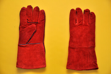 Welder's gloves on a yellow background. Protective accessory for welding.