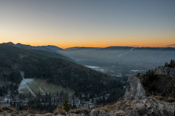 Panoramic view of sunset over Tatra Mountains, Zakopane town and Podhale region. The view from Nosal Peak. Selective focus on the ridge, blurred background.