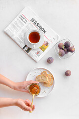 Woman with jar of sweet fig jam on table