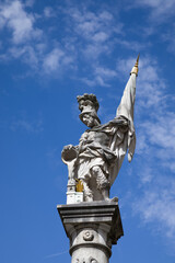 The St. Florian statue against the blue sky with clouds on Old Market Square (Alter Markt) in the...
