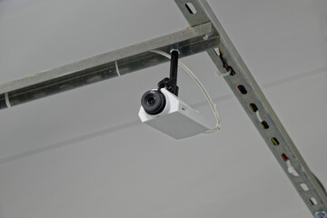 Surveillance camera on a bracket mounted on the ceiling