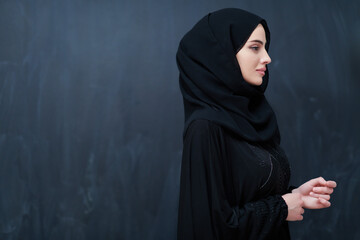 Modern young muslim woman in black abaya