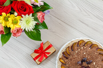 Chocolate cake decorated with plums and flowers
