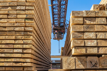 Wooden boards, lumber, industrial wood an timber under the gantry crane.