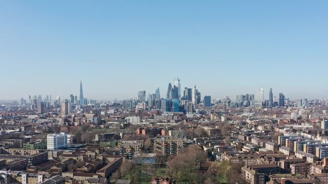 Slider drone shot over residential buildings tower hamlets towards city of London skyscrapers
