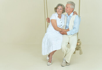 Obraz na płótnie Canvas cheerful senior couple on swing