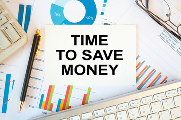 Obraz premium TIME TO SAVE MONEY is written in a document on the office desk, diagram and keyboard