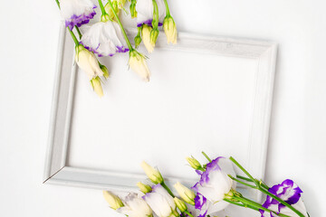 Flowers composition romantic. Spring flowers, photo frame on pastel background. Flat lay, top view, copy space