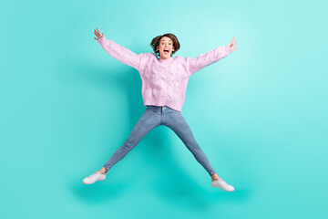 Fototapeta na wymiar Full length photo of funny charming young woman wear violet sweater jumping like star isolated turquoise color background