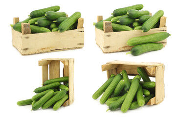 fresh green baby cucumbers in a wooden crate on a white background