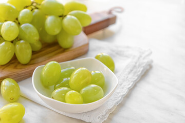 Plate with ripe green grapes on table