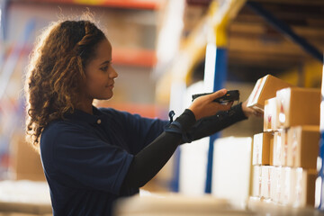 Portrait of African American worker in warehouse, International export business concept, occupation industrial in factory storage, warehouse worker using bar code scanner to analyze newly arrived good