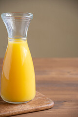 Top view of bottle of orange juice on wooden table and table, in vertical with copy space