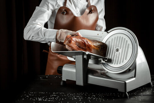 Dry Spanish ham on cutting machine, Iberian ham cutter on black background