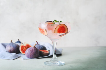 Glass of tasty fig lemonade on table