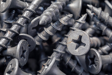 A handful of self-tapping screws for wood. Construction abstraction. Industrial background.