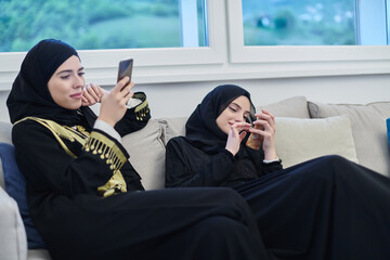 Portrait of Arabian girls wearing modern abaya using mobile phone