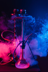 Fashionable hookah with a cloud of smoke on a black background with red and blue glow - obrazy, fototapety, plakaty