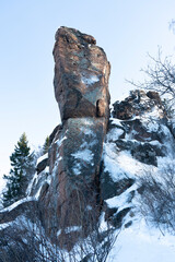 A brown rock with sparse, partially weathered snow.