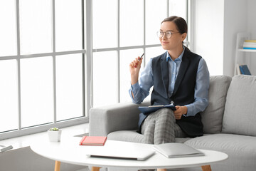 Portrait of female psychologist sitting on sofa in office