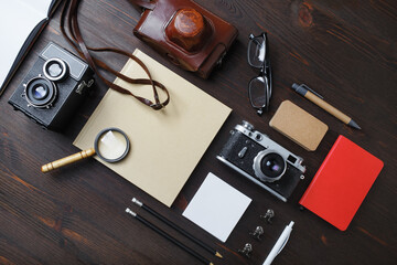 Retro still life. Old photo camera and vintage stationery on wood table background. Flat lay.