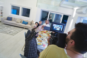 Professional videograph recording video while Muslim family having iftar together during Ramadan