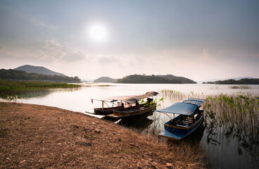 Thai traditional wooden longtail boat and beautiful River, sky, mountains.