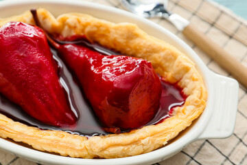 Baking dish of tasty poached pears in wine sauce, closeup