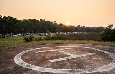 Phetchaburi, Thailand – February 26, 2021:  Helicopter landing area and tents of many tourists, sunrise in the morning.