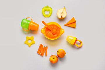 Composition with healthy baby food and accessories on light background
