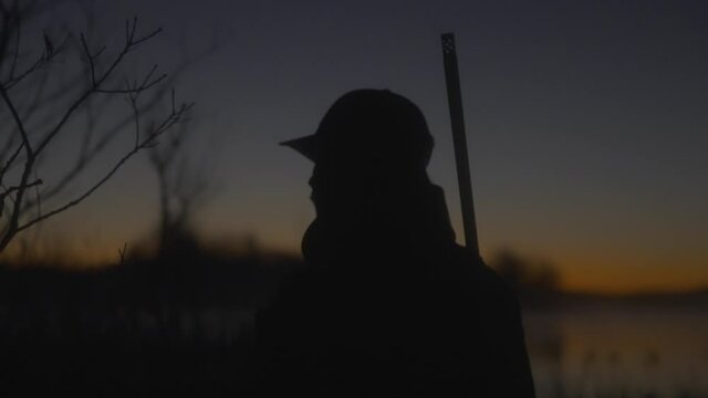 A hunter scans the field at sunrise.