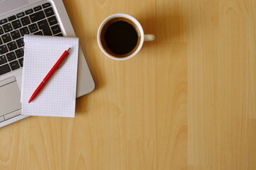 Work from Home. Office set with laptop, notebook, coffee cup, pen on wooden table. Business concept. Flat lay top view copy space.