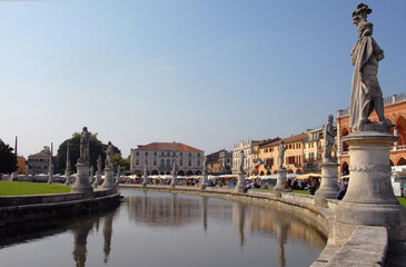 Prato della Valle is a large elliptical square with statues, fountains and colorful houses. It is the largest square in Padua and the largest in Europe.