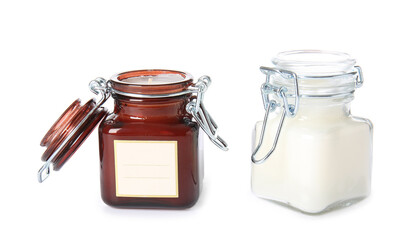 Wax candles in jars on white background