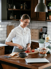 Happy woman enjoying in the kitchen. Beautiful woman making salad