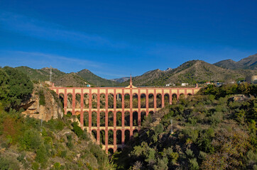 Ancient aqueaduct close to town Nerja in Andalusia, Spain. Aqueduct Eagle. Blue sky in the background. Summer travelling in Spain.