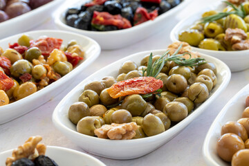 varieties of olives on the plate on a white background