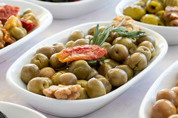 varieties of olives on the plate on a white background