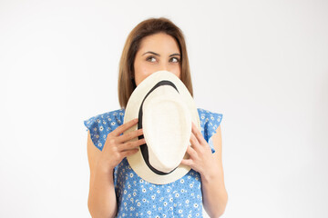 Beautiful young woman laughing woman in blue dress and straw hat looking happy over white background